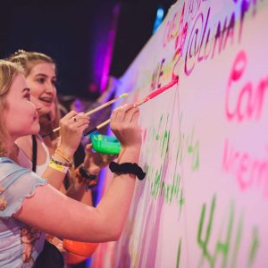 Eventmodul Freundeswand: Gäste durften sich mit Neon Farbe auf einer weißen Leinwand verewigen